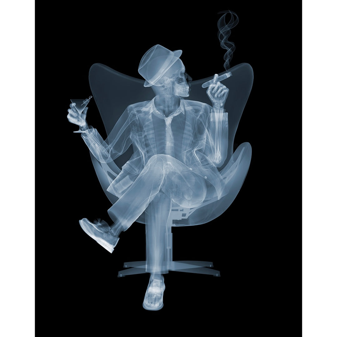 skeleton looking to the right sitting in chair with legs crossed smoking cigar drinking martini wearing hat and suit on black background