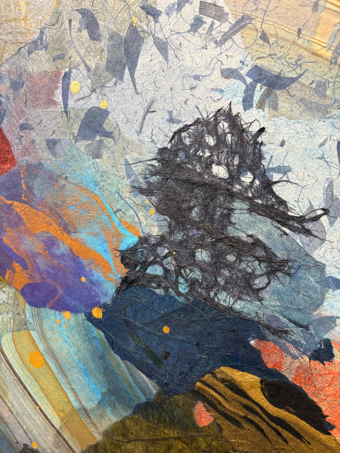 Detail shot of Born to Bloom by Christopher Peter — close-up of the dark floral collage area featuring layered indigo and black botanical paper cutouts with acrylic paint washes in blue, orange, and gold