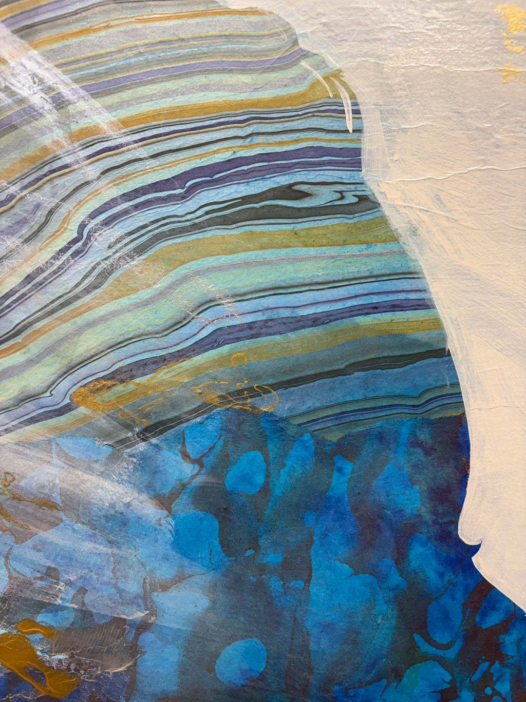 Close-up detail of Current Cameo showing the striated upper portion of the silhouette with flowing horizontal layers of blue, teal, gold, and beige, resembling geological strata in mixed media.