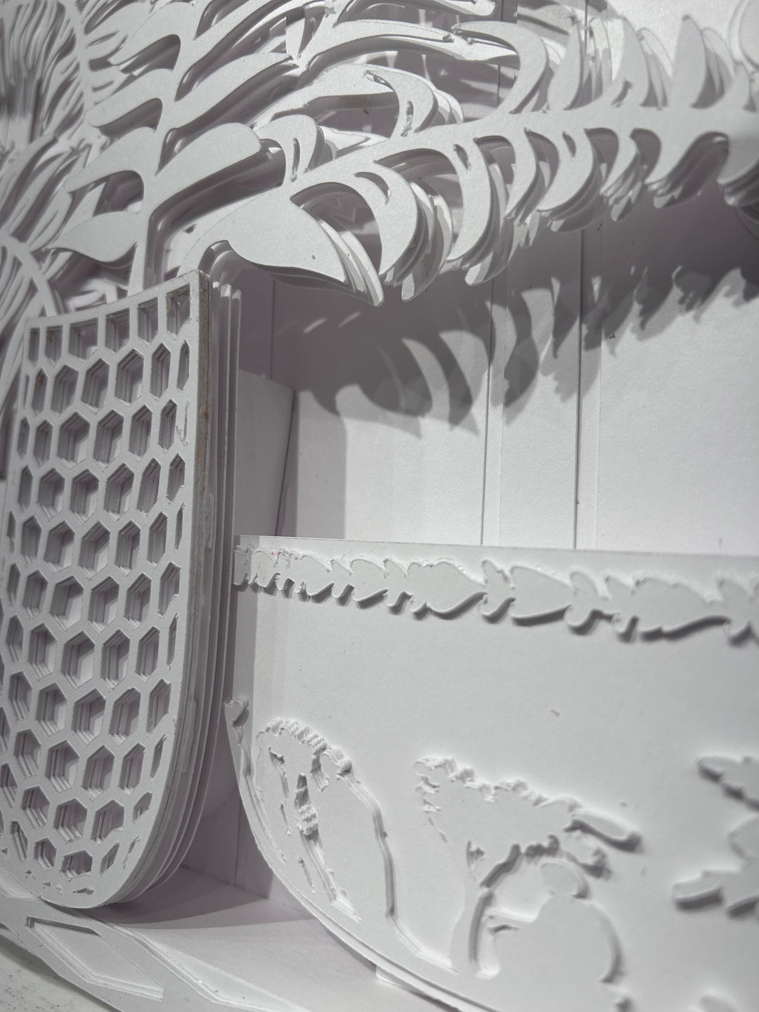 14"x14" layered white paper forming a vase with a fern over a wall.  
