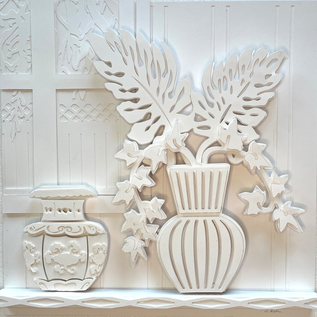 14"x14" layered white paper forming a fern in a striped vase on a wall. 