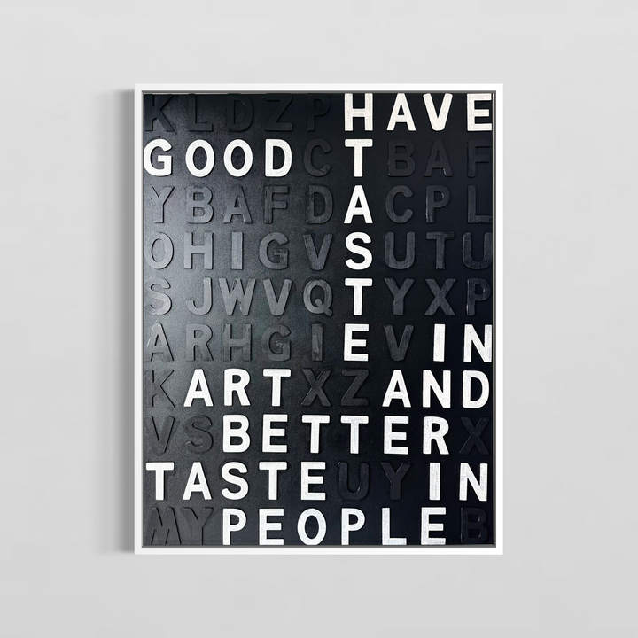 Steffanie Gerkin’s Have Good Taste Black 3D is a contemporary mixed-media typography artwork made with raised wood and acrylic letters on canvas, featuring a black monochrome alphabet grid with contrasting white letters that spell phrases including “Have Good Taste,” “Art,” “Better Taste,” and “People.”