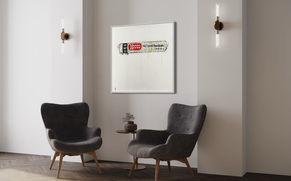 Necco framed in white hanging on white wall above two grey armchairs