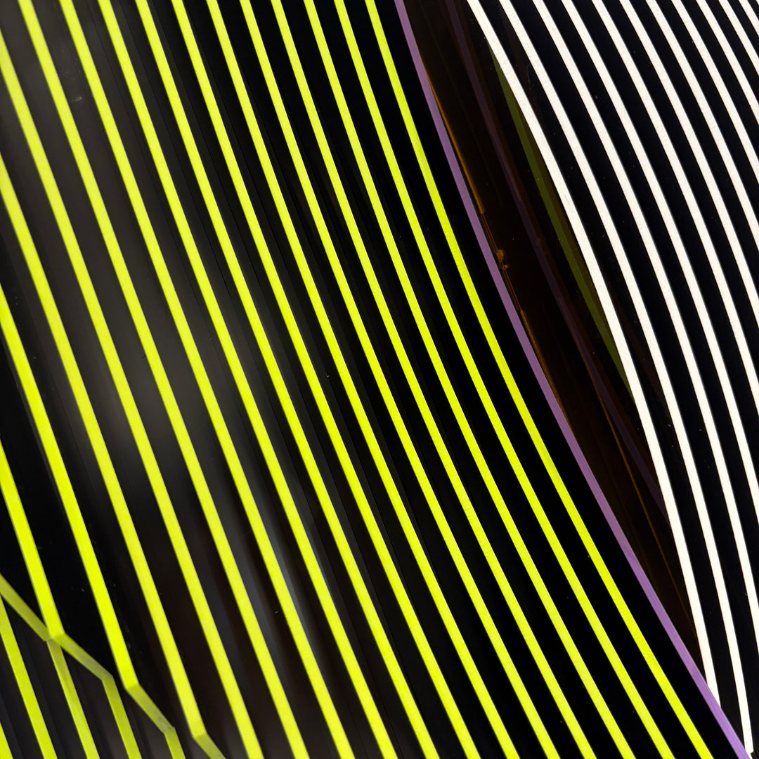 vertical stripes in black and yellow with circle in center offset optical illusion stripes with pink purple stripe down the middle