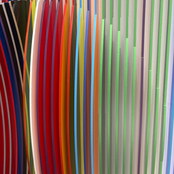 from view vertical stripes on white background in rainbow colors all convex and concave optical illusion to create circle from front, jagged from side and color more prominent