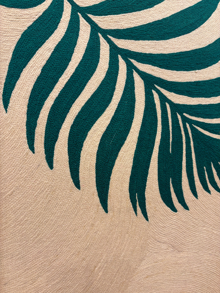 Two green palm fern leaves green on cream tan background in stitched embroidery chain textile fabric 