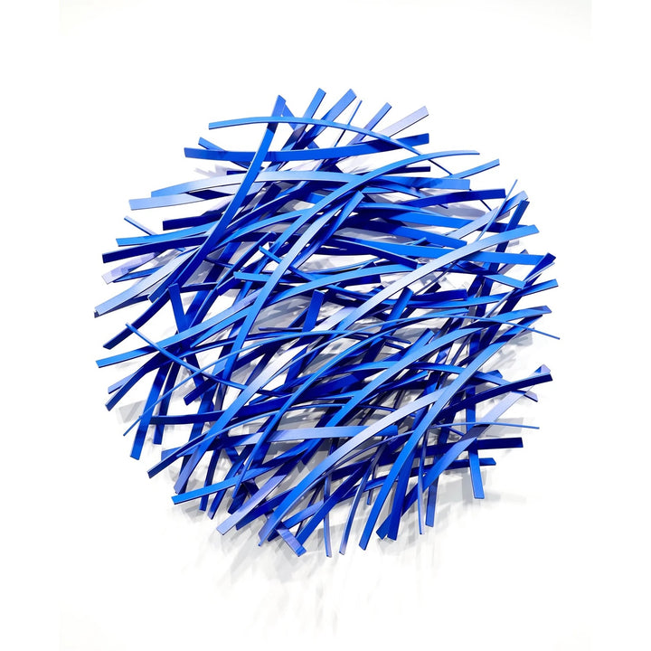 Matt Devine, Thin Bands, powder-coated aluminum, made to order from 11 to 84 inches. Round wall sculpture of thin, curved aluminum strips in royal blue, navy, and light blue, layered in a dense crisscross pattern on a white wall.
