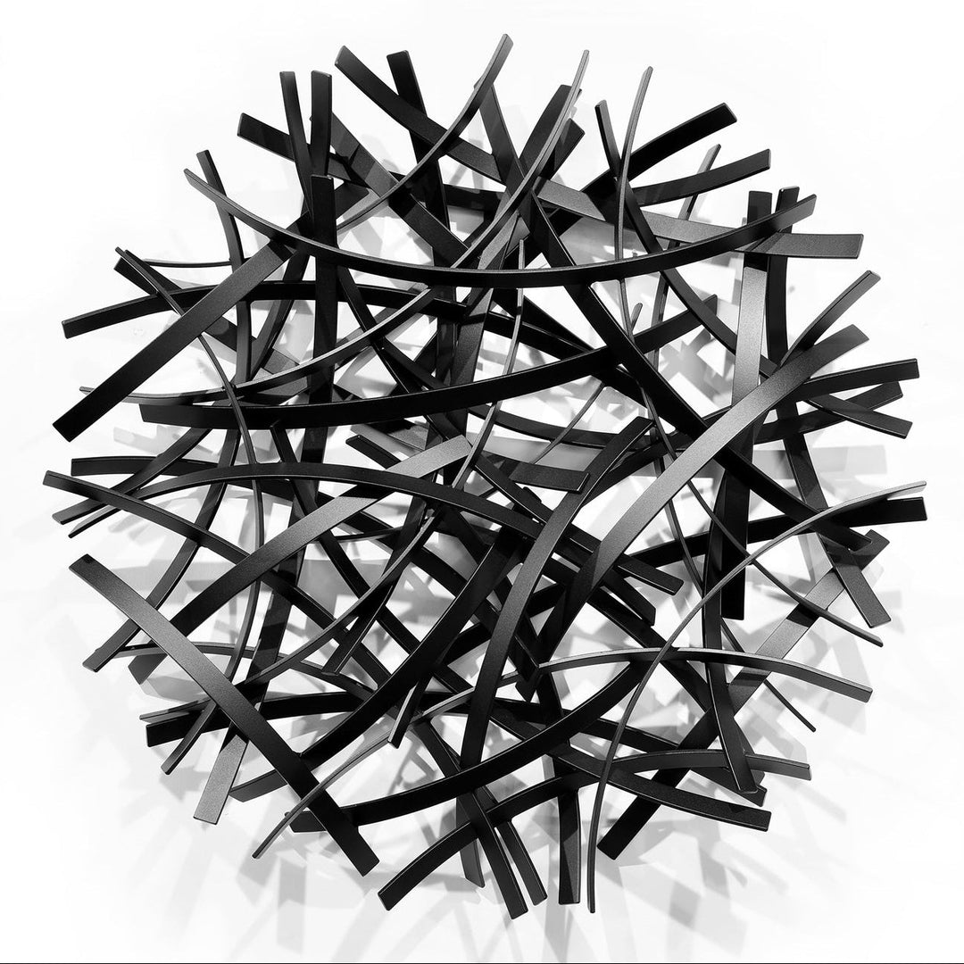 Matt Devine, Thin Bands, powder-coated aluminum, made to order from 11 to 84 inches. Round wall sculpture of thin, curved black and dark grey aluminum strips layered in an open crisscross pattern on a white wall.