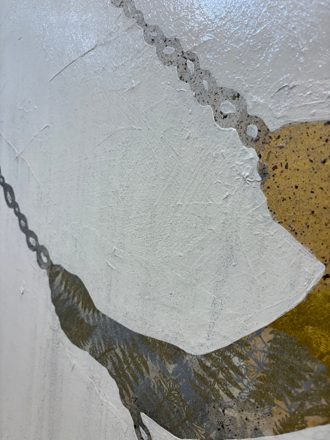 Close-up detail of Swinging Silhouettes II showing a chain-link swing rope against heavily textured white and gray canvas, with a golden amber handmade paper element and dark botanical-patterned paper below.