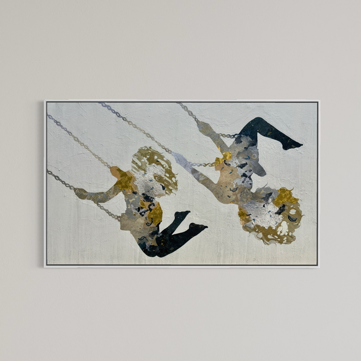 Swinging Silhouettes II by Christopher Peter presented in a thin silver frame on a light gray background, showing the full horizontal composition of the two swinging figures.
