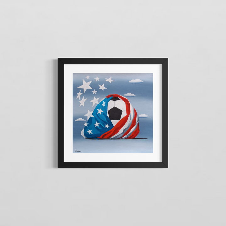 "Soccer in USA" by Italian artist Carlo Trevisan — a surrealist oil painting on canvas depicting a classic black and white soccer ball dramatically wrapped in a billowing American flag, with oversized white stars bursting free against a cloudy blue sky. The bold, celebratory composition unites the world&