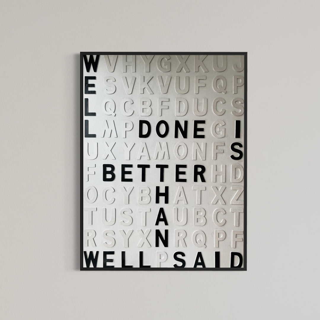 Contemporary 3D text artwork by Chicago artist Steffanie Gerkin titled Well Done 3D, featuring raised black and white wood letters arranged in a structured alphabet grid on a white canvas. The monochrome typographic composition spells the phrase “Well Done Is Better Than Well Said,” creating a bold conceptual wall art piece with graphic text-based design, pop art influence, and contemporary mixed-media style.
