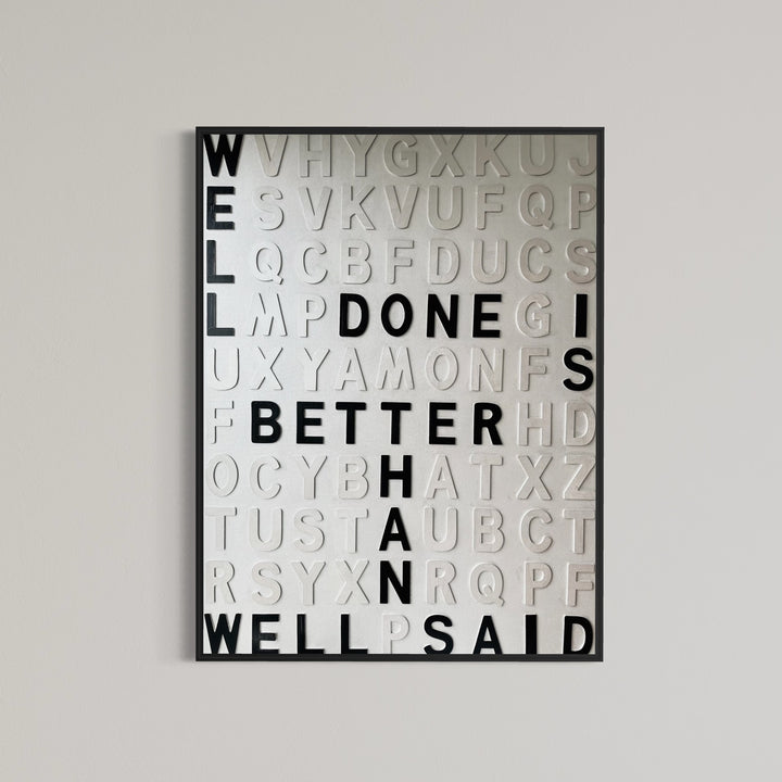 Contemporary 3D text artwork by Chicago artist Steffanie Gerkin titled Well Done 3D, featuring raised black and white wood letters arranged in a structured alphabet grid on a white canvas. The monochrome typographic composition spells the phrase “Well Done Is Better Than Well Said,” creating a bold conceptual wall art piece with graphic text-based design, pop art influence, and contemporary mixed-media style.