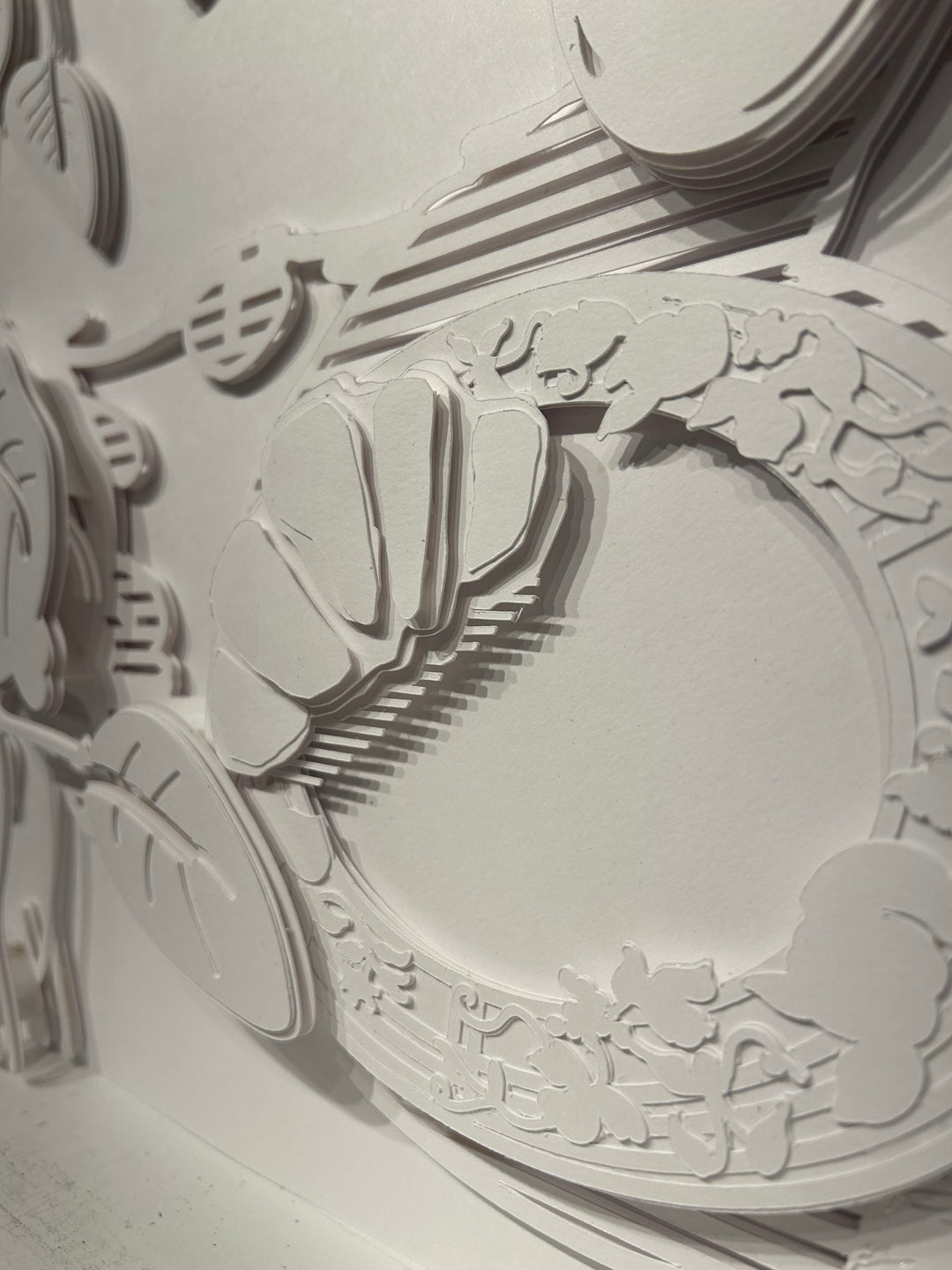 14"x14" layered white paper forming a table with breakfast and vegetation.  