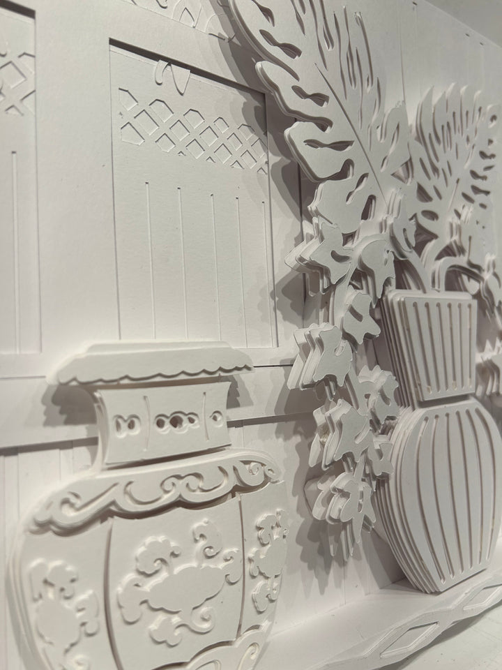14"x14" layered white paper forming a fern in a striped vase on a wall. 