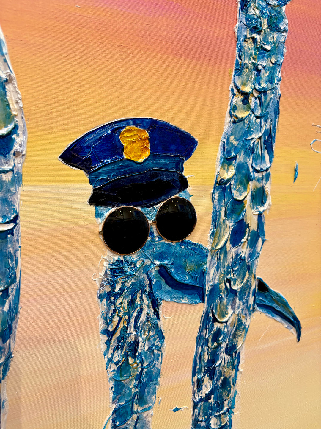 48" x 48" acrylic on canvas painting of blue birds with hats and eyes made of washers over a pink and yellow gradient background. 